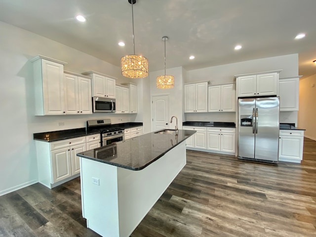 kitchen with white cabinets, stainless steel appliances, dark hardwood / wood-style floors, and an island with sink