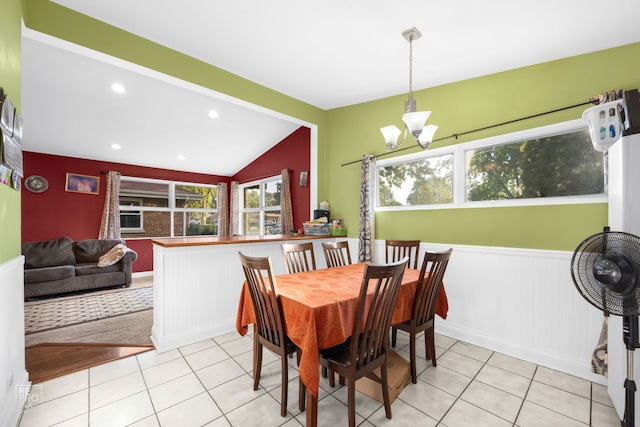 tiled dining space featuring vaulted ceiling, a notable chandelier, and a healthy amount of sunlight