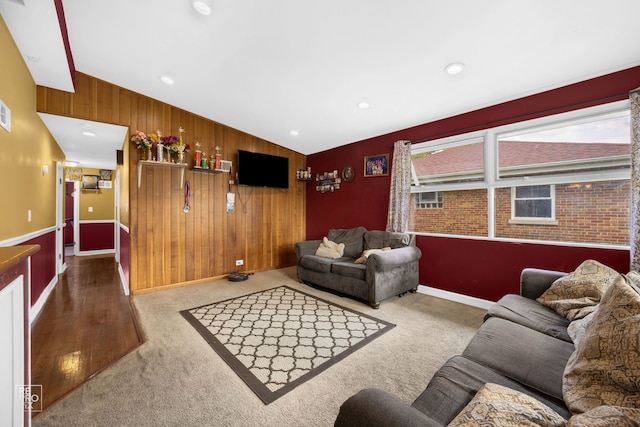 carpeted living room featuring wooden walls and vaulted ceiling