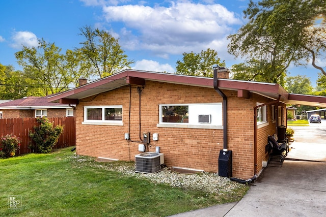 view of side of home with a yard and central AC unit