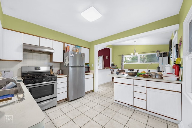 kitchen featuring tasteful backsplash, stainless steel appliances, vaulted ceiling, pendant lighting, and white cabinets