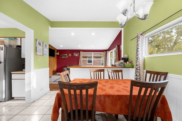 tiled dining space featuring vaulted ceiling