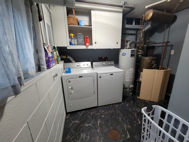 laundry room featuring cabinets, gas water heater, and washer and dryer