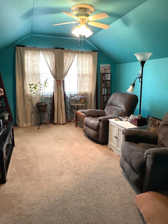 sitting room with ceiling fan, light colored carpet, and vaulted ceiling