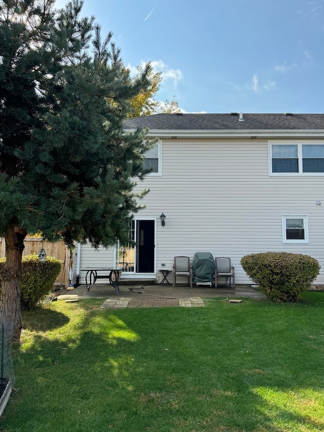 rear view of house with a lawn and a patio