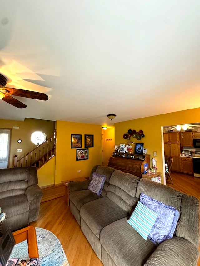 living room featuring ceiling fan and light hardwood / wood-style flooring