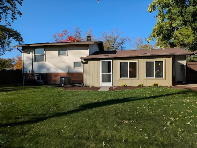 back of property with cooling unit and a yard