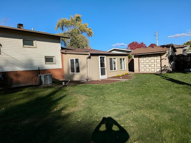 back of house featuring central air condition unit and a yard