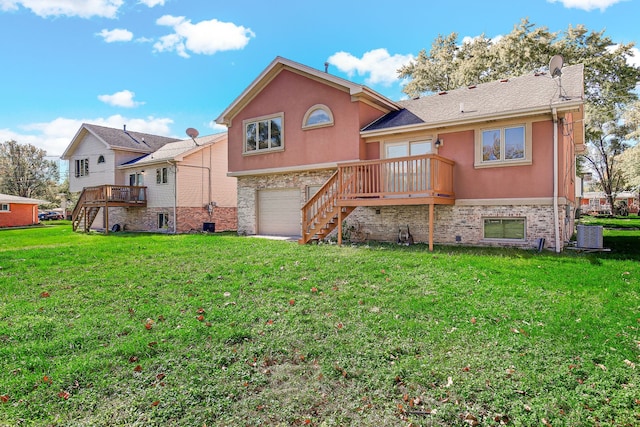 back of property featuring a wooden deck, a yard, and a garage