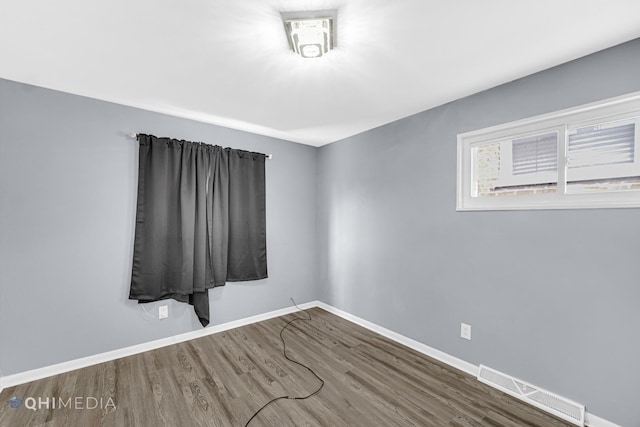 spare room featuring wood-type flooring