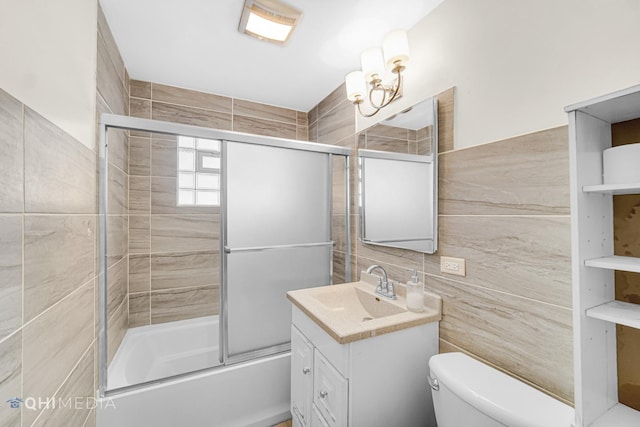 full bathroom featuring tile walls, vanity, shower / bath combination with glass door, and toilet