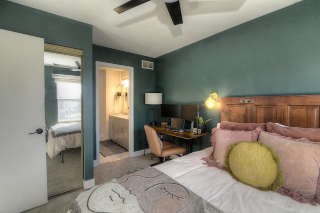 bedroom with connected bathroom, light colored carpet, and ceiling fan