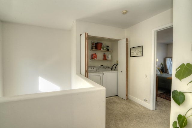 clothes washing area featuring washing machine and dryer and light carpet