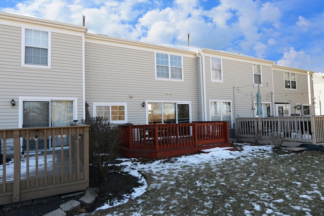 snow covered house featuring a deck