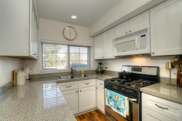 kitchen featuring white cabinetry, gas range, sink, and light stone counters