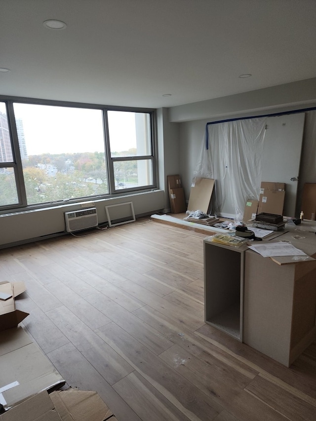 unfurnished office featuring a wall mounted AC and light hardwood / wood-style flooring