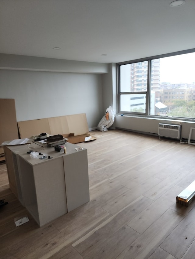 interior space with an AC wall unit and light hardwood / wood-style flooring