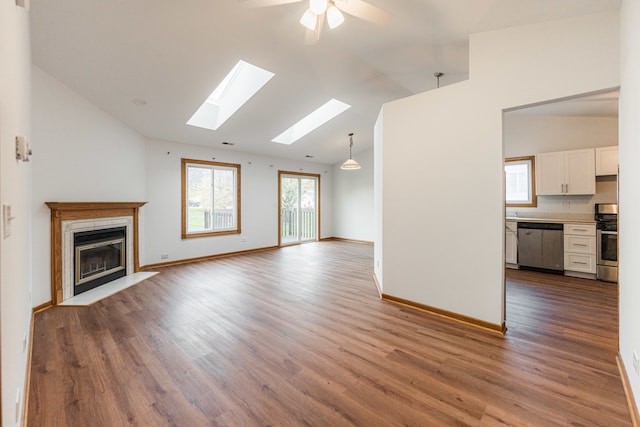 unfurnished living room featuring dark hardwood / wood-style floors, ceiling fan, high vaulted ceiling, and a tiled fireplace