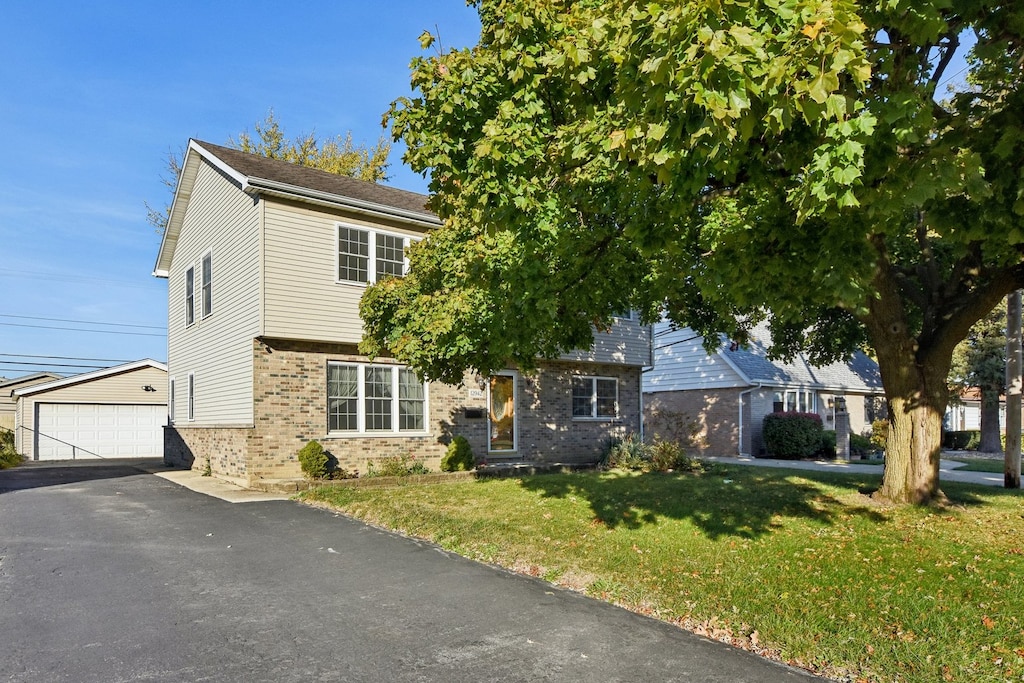 obstructed view of property featuring a garage and a front lawn