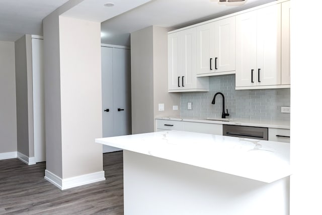 kitchen featuring light stone counters, sink, dark hardwood / wood-style floors, and white cabinets