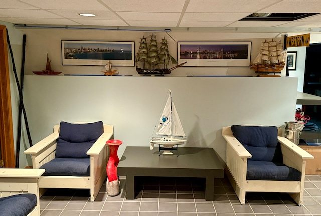 living area featuring a paneled ceiling and tile patterned floors