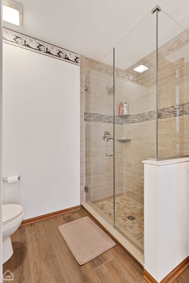 bathroom with toilet, walk in shower, and hardwood / wood-style floors