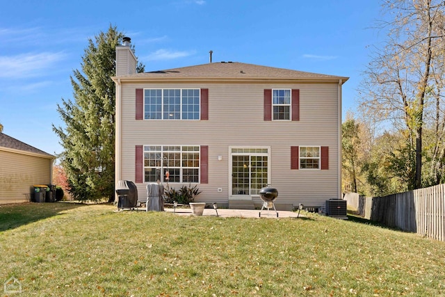 back of property with central AC, a yard, and a patio area