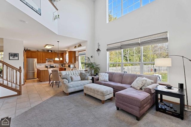 living room featuring a healthy amount of sunlight, light tile patterned flooring, and a high ceiling