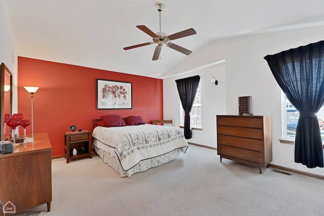 bedroom featuring lofted ceiling, light carpet, multiple windows, and ceiling fan