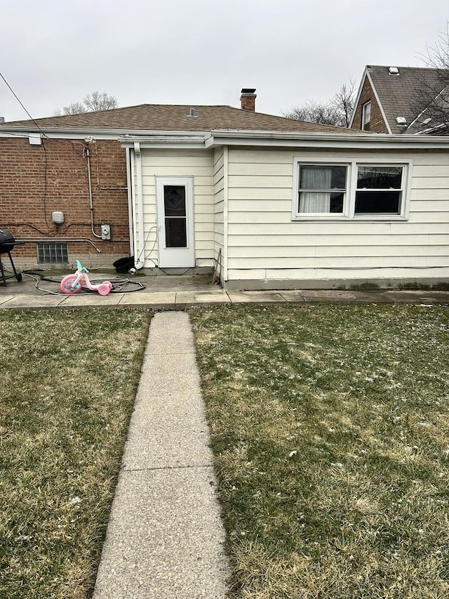 back of property featuring a lawn and a patio area