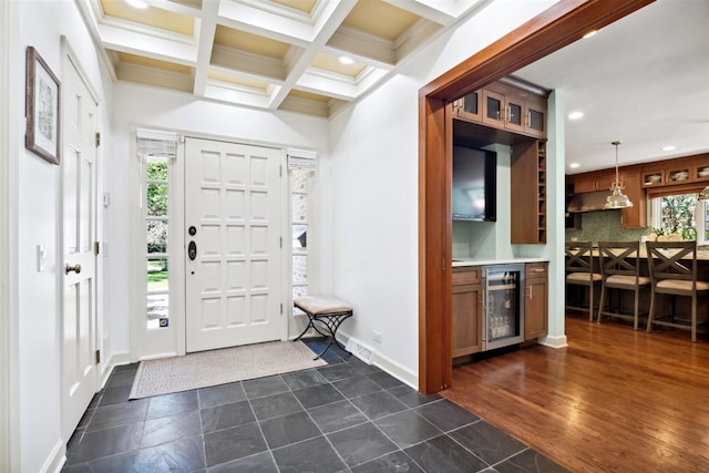 foyer featuring coffered ceiling, a healthy amount of sunlight, dark hardwood / wood-style flooring, and beverage cooler