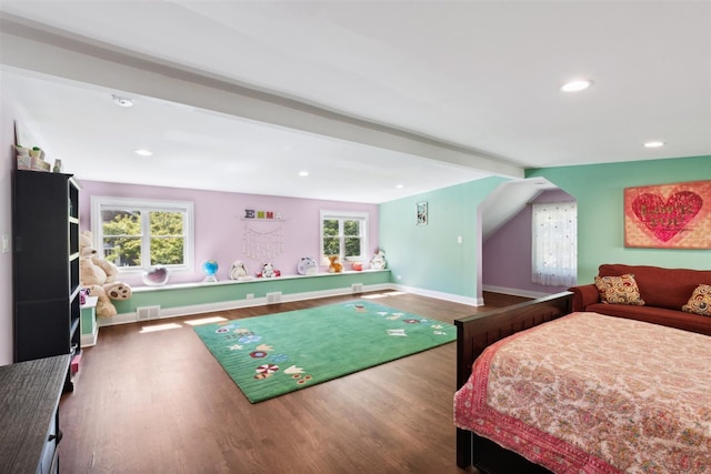 bedroom with beamed ceiling and hardwood / wood-style flooring