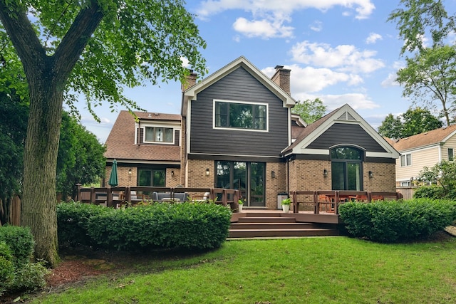 back of house with a deck and a lawn