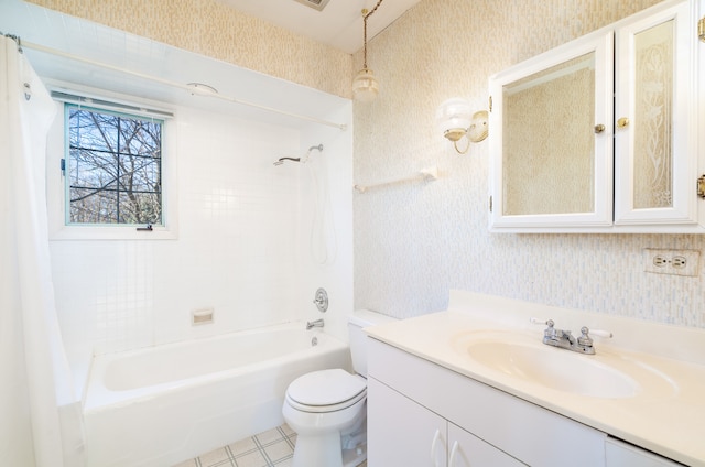 full bathroom with vanity, tiled shower / bath combo, and toilet