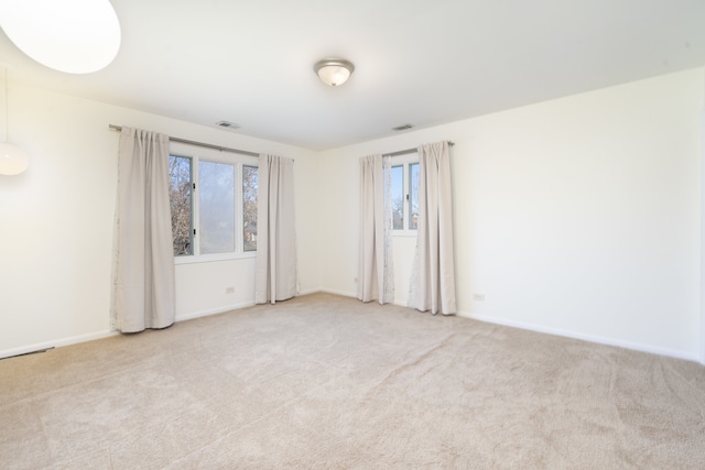 unfurnished room featuring light carpet