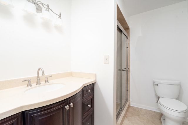 bathroom with tile patterned flooring, vanity, toilet, and a shower with shower door