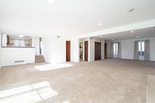 unfurnished living room featuring light colored carpet