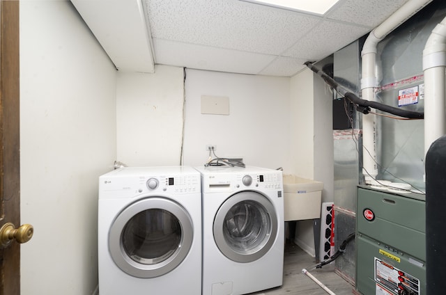 laundry area featuring hardwood / wood-style flooring, independent washer and dryer, and sink