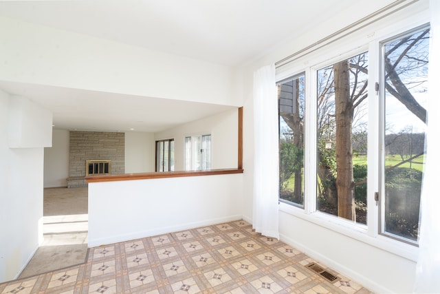 spare room featuring plenty of natural light and a fireplace