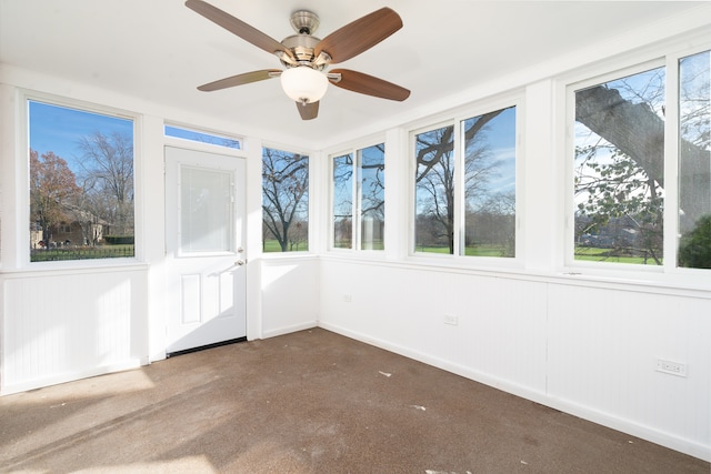 unfurnished sunroom featuring ceiling fan and plenty of natural light