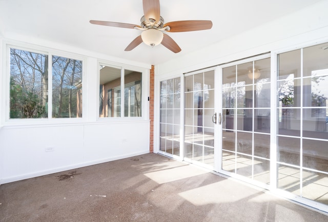 unfurnished sunroom featuring ceiling fan