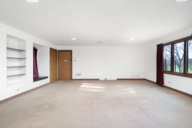 carpeted empty room with a textured ceiling