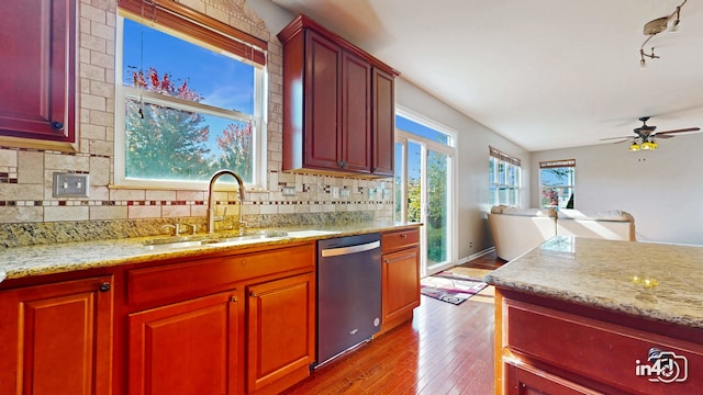 kitchen featuring tasteful backsplash, sink, dishwasher, ceiling fan, and light hardwood / wood-style flooring