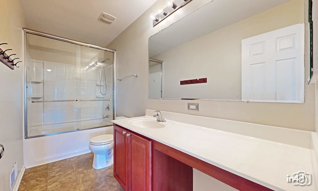 full bathroom featuring vanity, shower / bath combination with glass door, and toilet