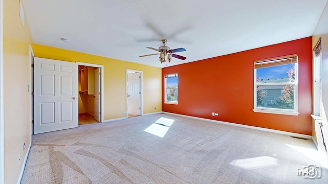 unfurnished bedroom featuring light carpet, ensuite bathroom, and ceiling fan