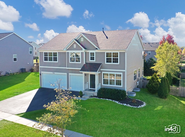 front of property featuring a front yard, a garage, and central air condition unit