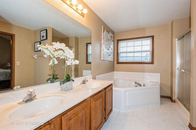 bathroom with tile patterned floors, a washtub, and vanity