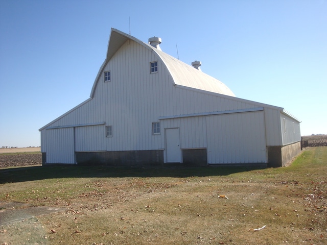 view of side of home featuring a yard and an outdoor structure