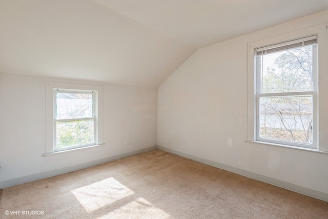 bonus room featuring a wealth of natural light, vaulted ceiling, and light colored carpet