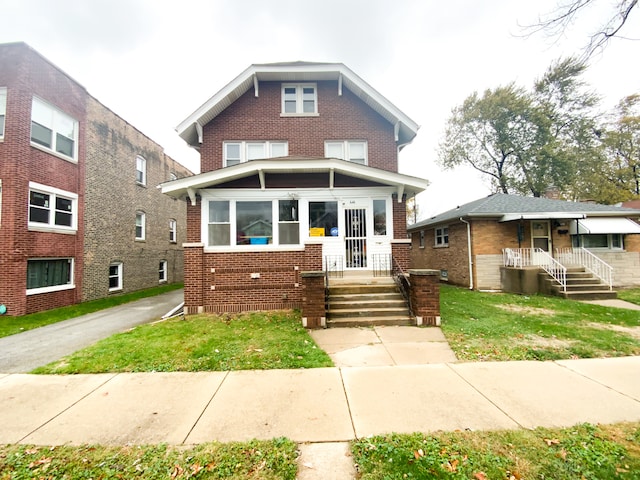 american foursquare style home with brick siding and a front yard